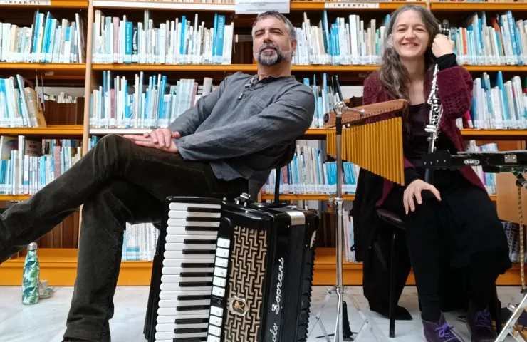 hombre y mujer sentado en una biblioteca con instrumentos musicales, acordeón