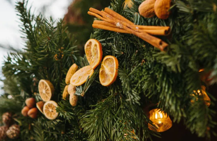 adornos de arbol de navidad hechos con ramas de canela y rodajas secas de naranja