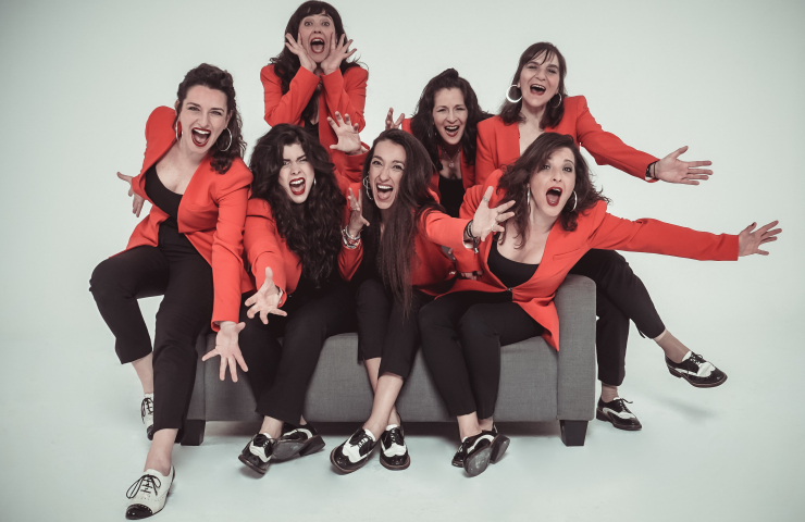 Grupo de mujeres vestidas de negro y rojo