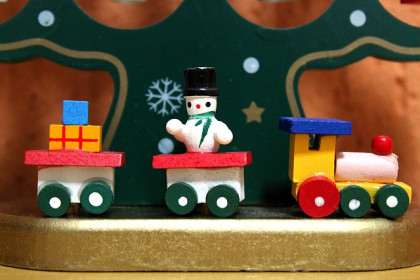 figurita de tren de madera con varios vagones, en uno de ellos va un muñeco de nieve