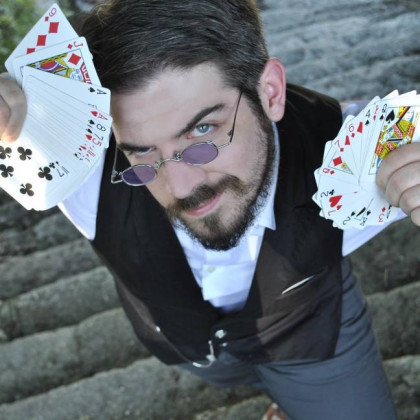 hombre con gafas de sol moradas, foto tomada desde arriba, baraja de cartas en las manos las abre en abanico